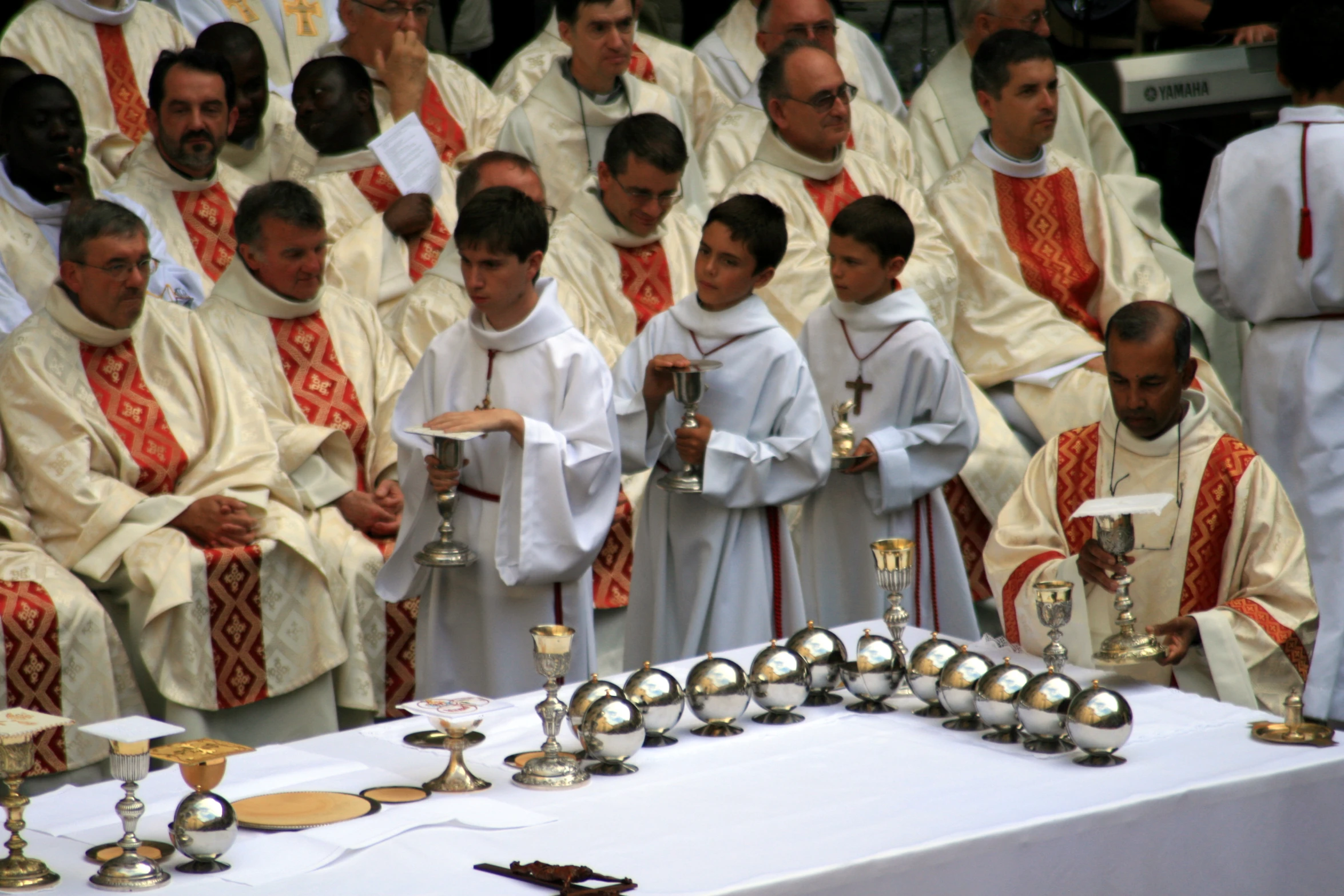 a group of men and women dressed in white standing around candles