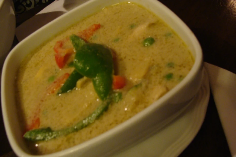 a bowl full of a green chili and white sauce