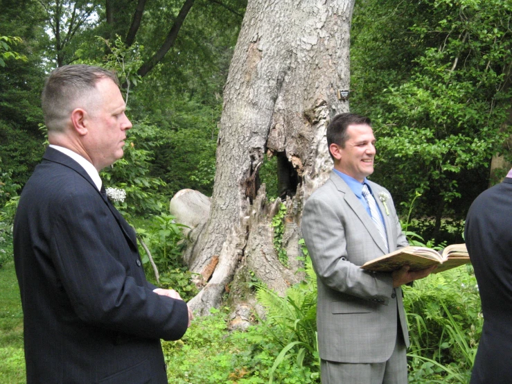 three men are getting married and having a conversation in the woods