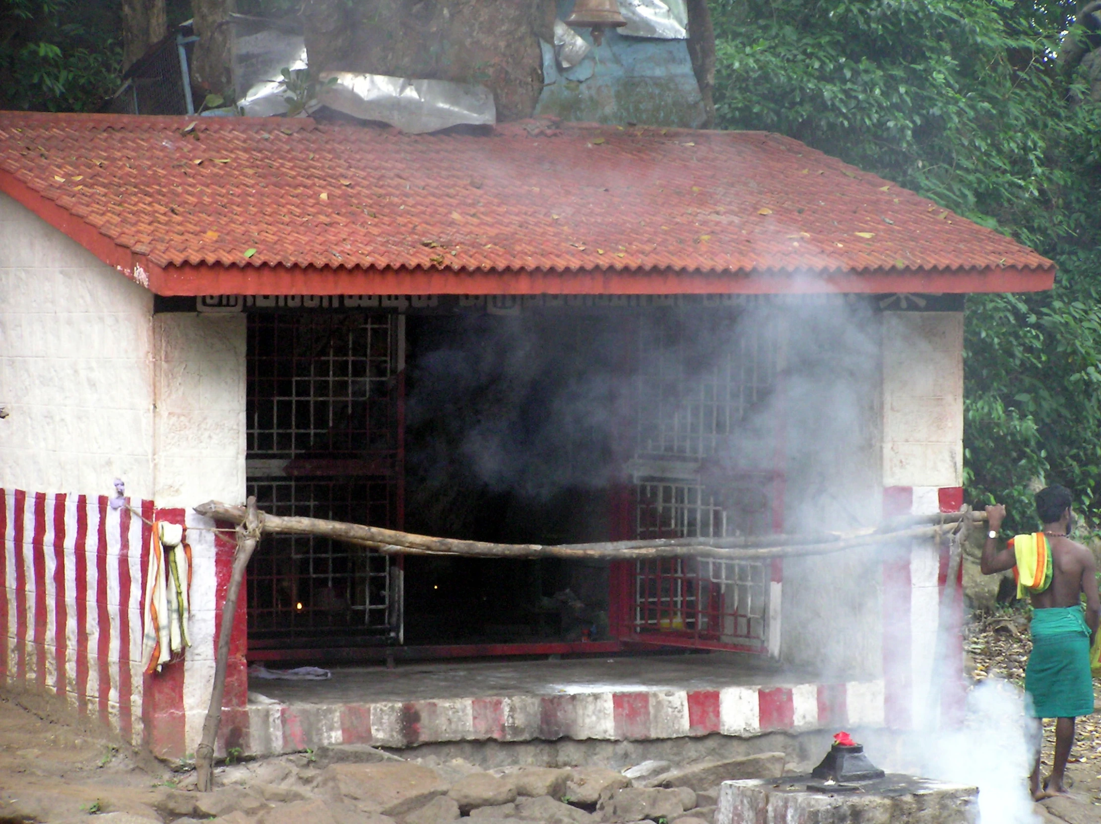 a man stands on the step in front of a building and smokes out