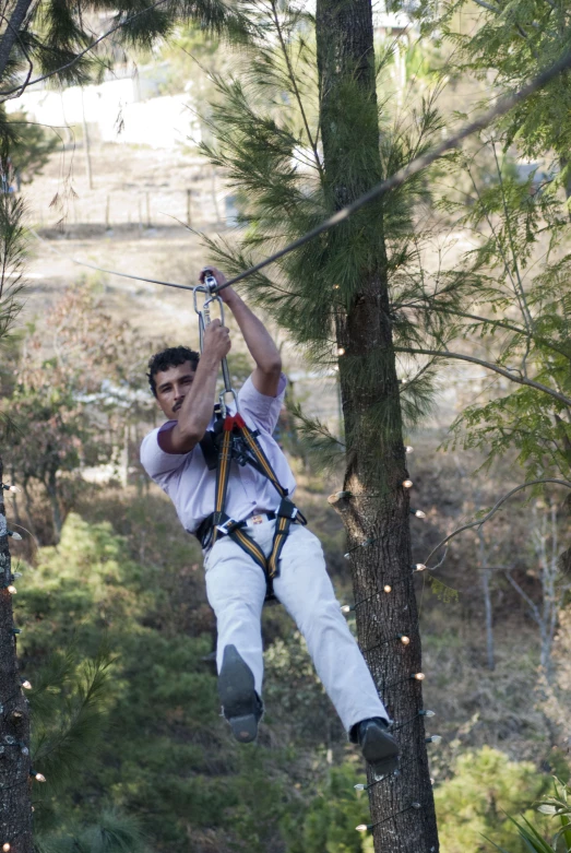 a man wearing an ear muff standing on a rope and roped on with a rope