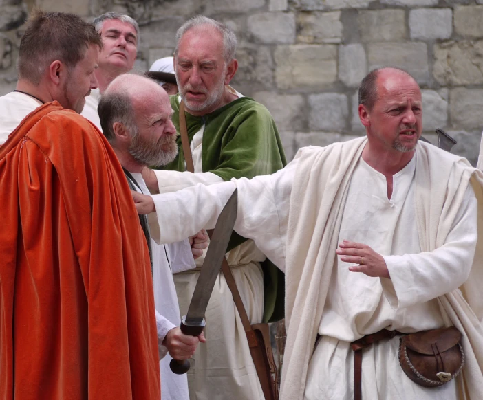 priests are exchanging hands and wearing brown robes