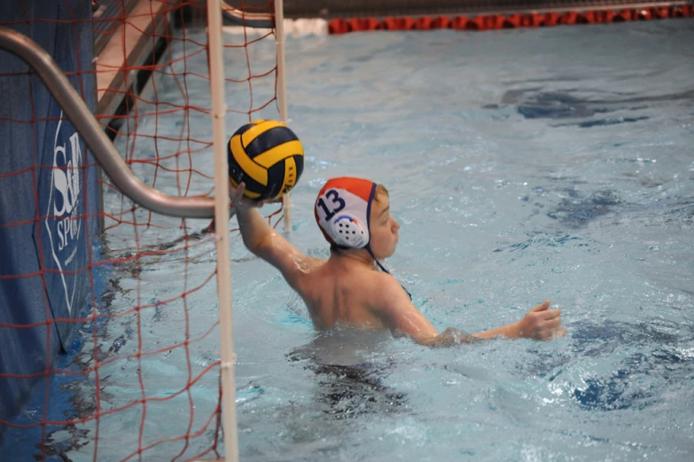 a young man swimming and playing volleyball
