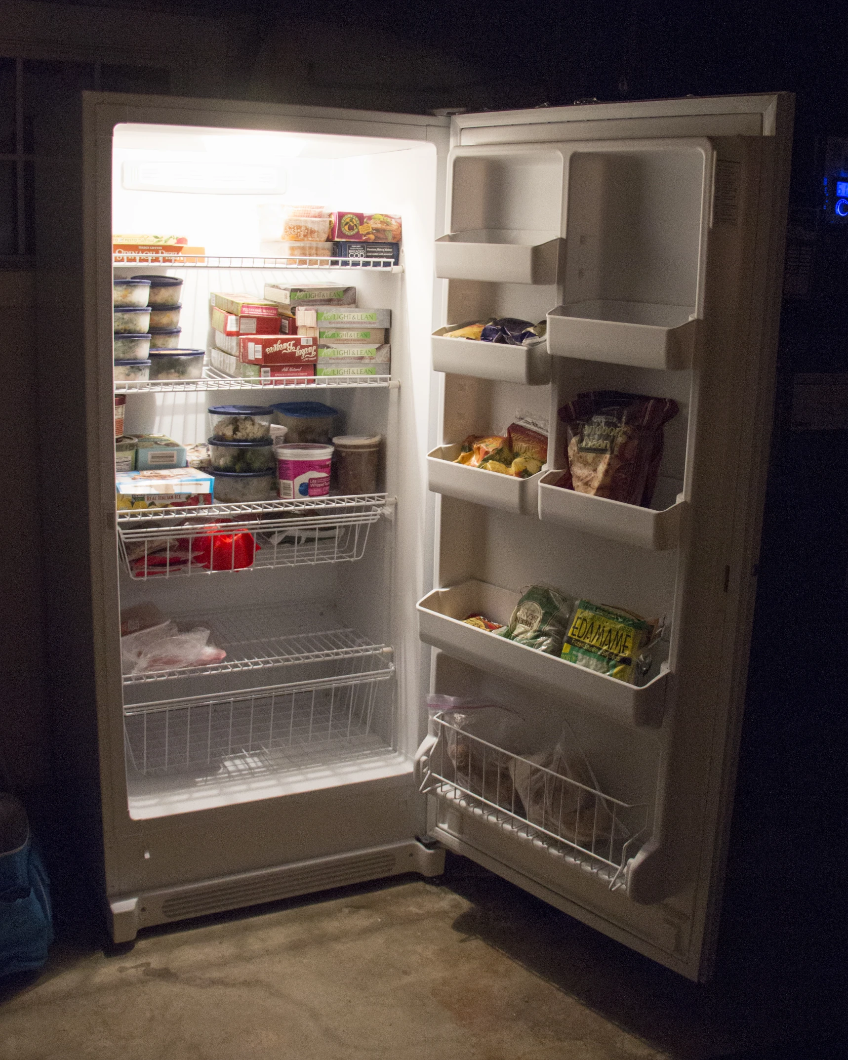 a fridge full of food and drinks in the dark