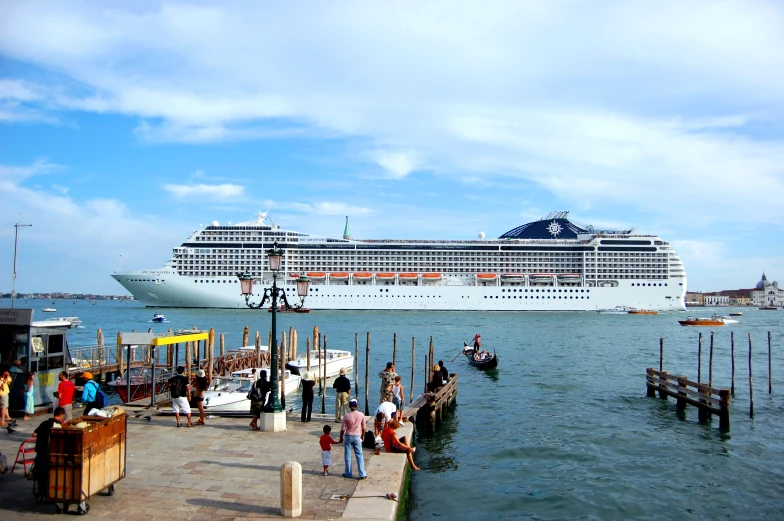 people are standing in front of a large boat docked on the water