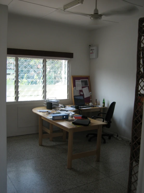 a table sitting in the corner next to an open window