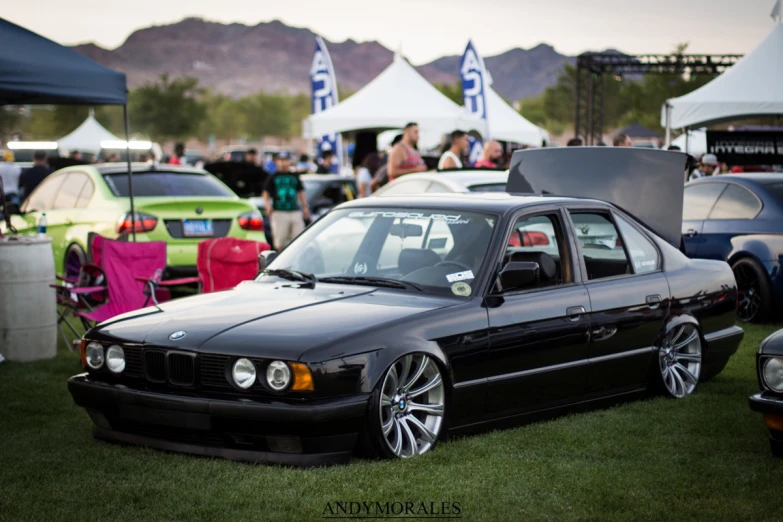 bmw car parked on grass in front of tents