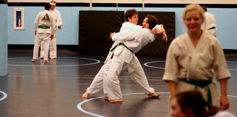 a man is demonstrating how to do a kick at a martial class