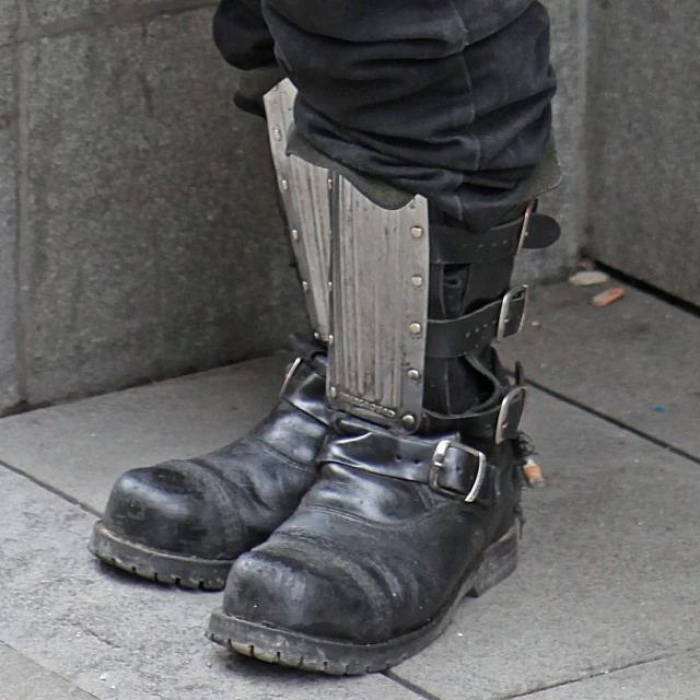 a man wearing black boots and leather pants