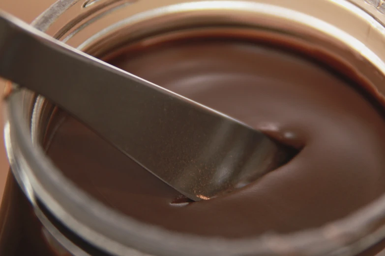 spoons in a jar full of melted chocolate