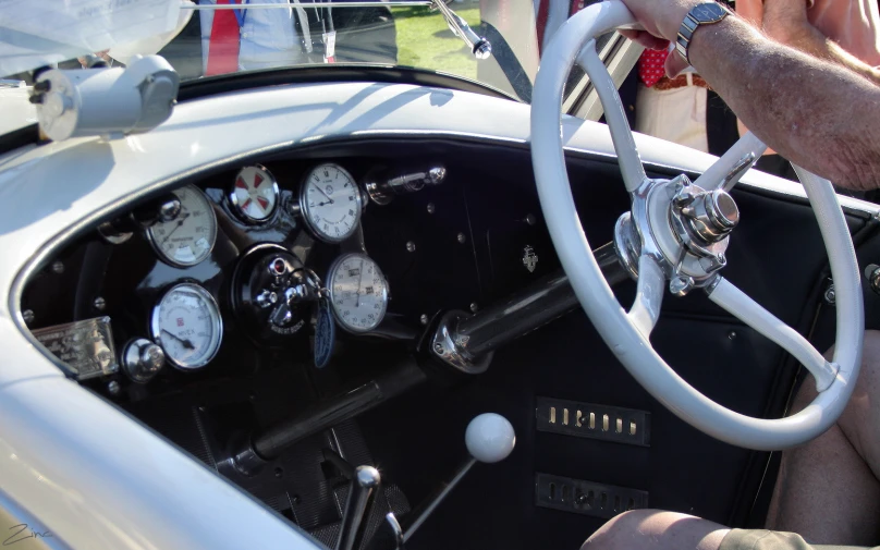 a meter and gauges in the center console of a white and black classic car