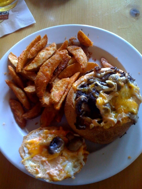 a white plate topped with two mini sandwiches and a pile of fries