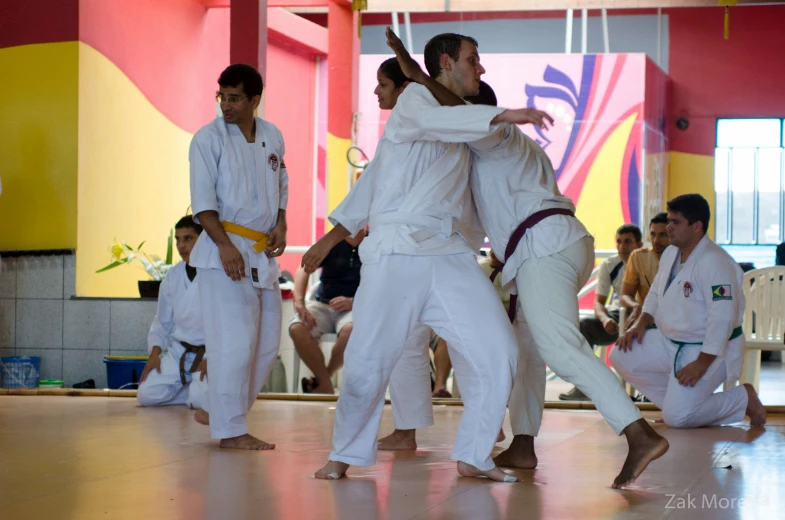 several men in white doing karate moves together