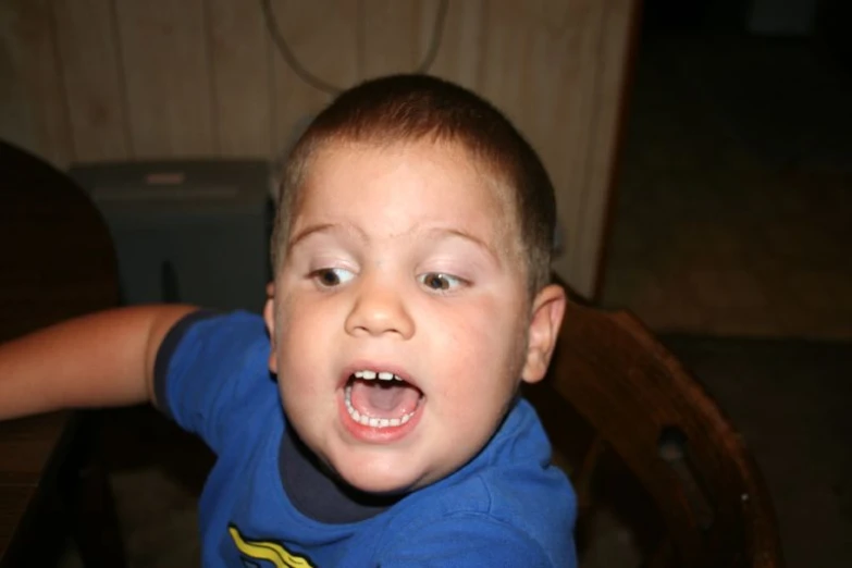 a little boy with a very big teeth and blue shirt on