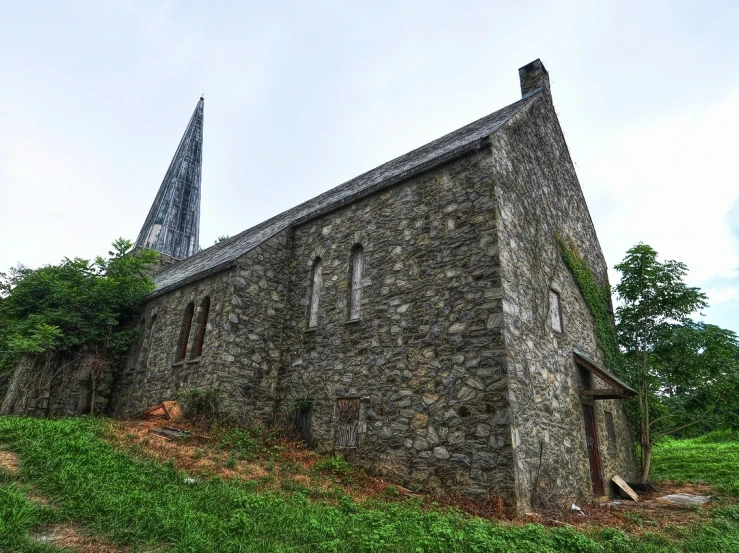 an old stone building with grass growing around it