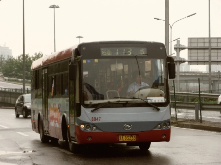 a bus traveling down a city street next to parked cars