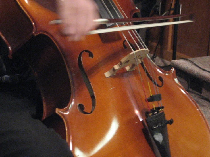a cello being played by someone in a room