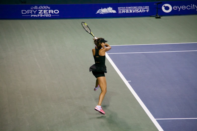 a woman runs toward the sideline on a tennis court