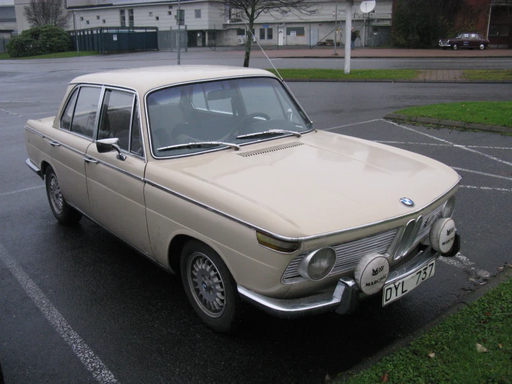 an old car sits parked in a lot