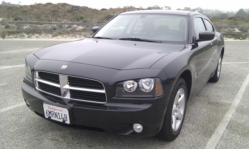 a black dodge charge parked in a parking lot