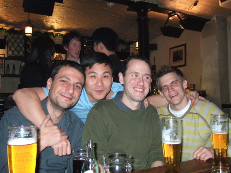 some men are sitting at a table together and having a good time