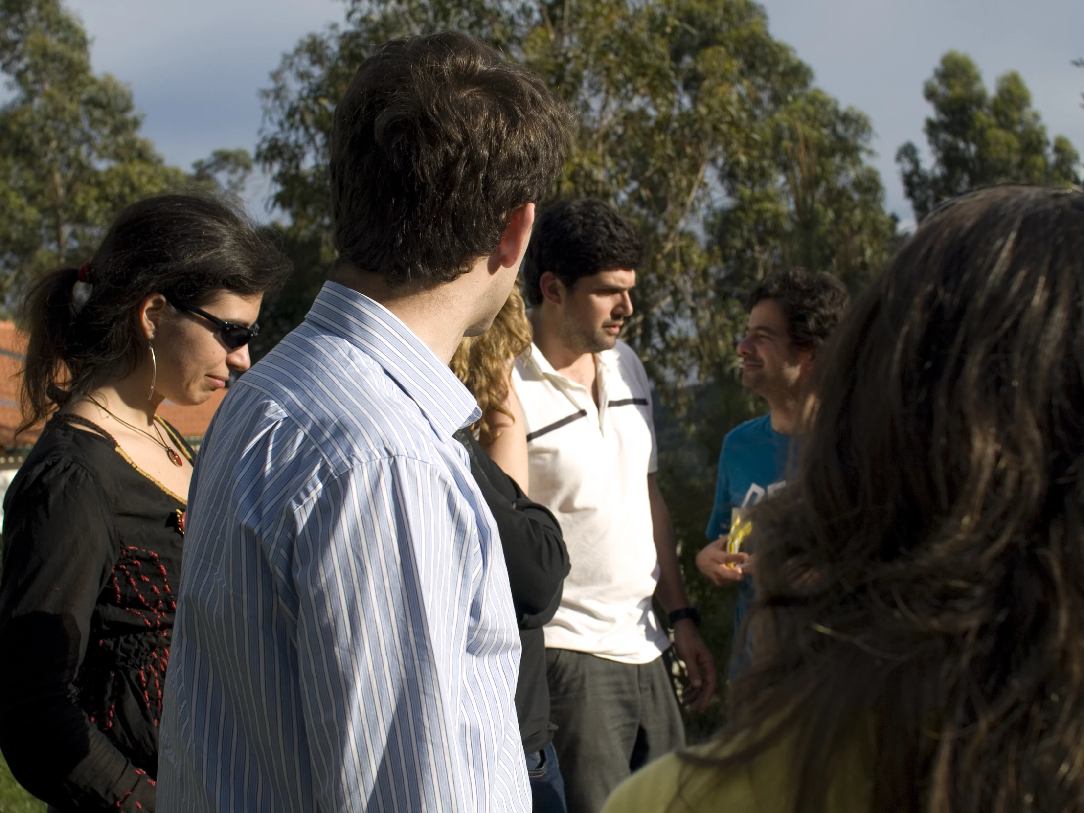 some people stand outside together with a man in the foreground and people in background