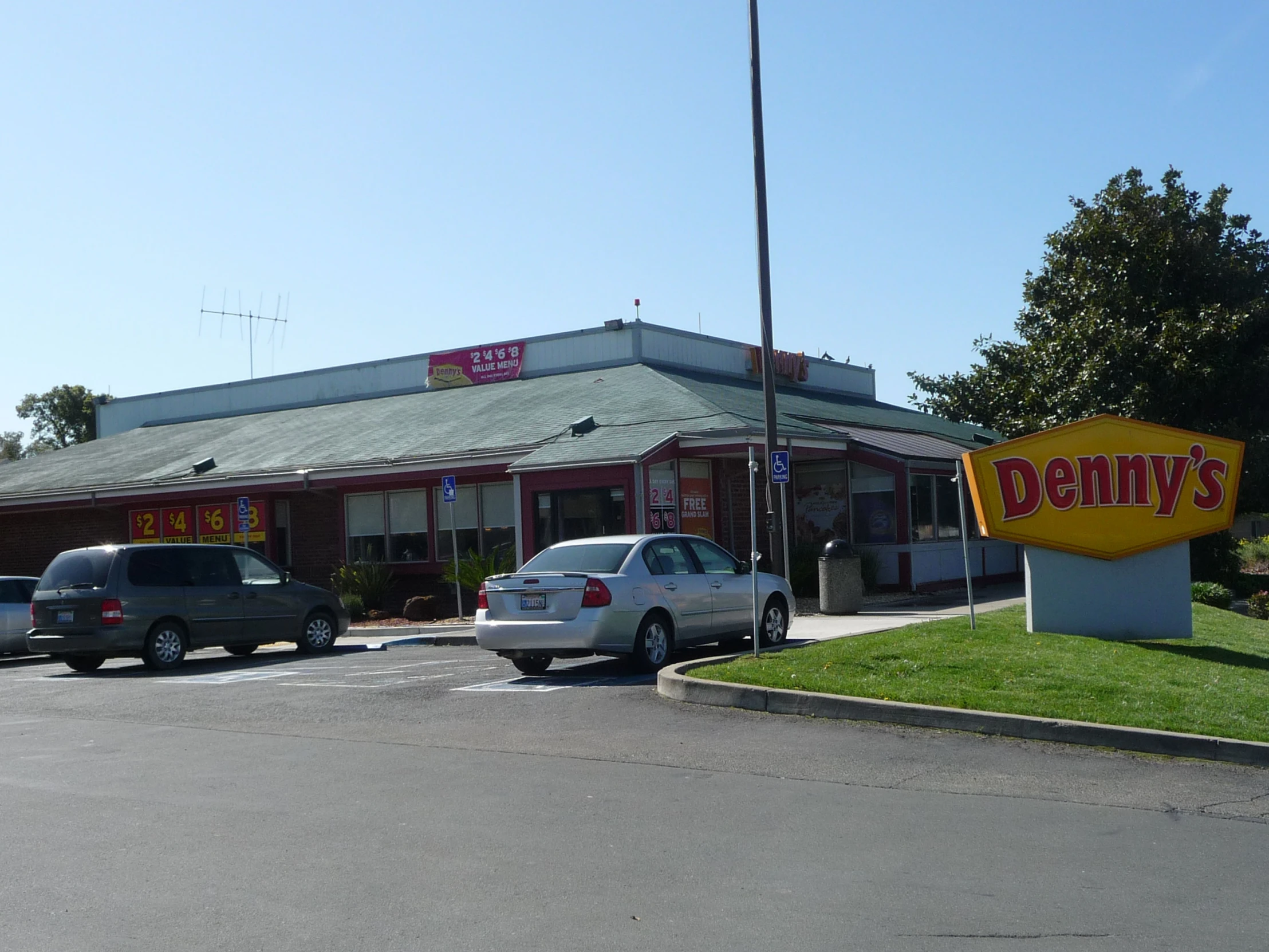 several vehicles parked in a parking lot at a dommie's diner