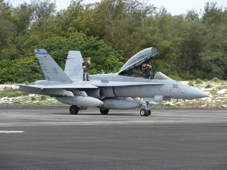 a fighter jet is parked on the tarmac near other airplanes