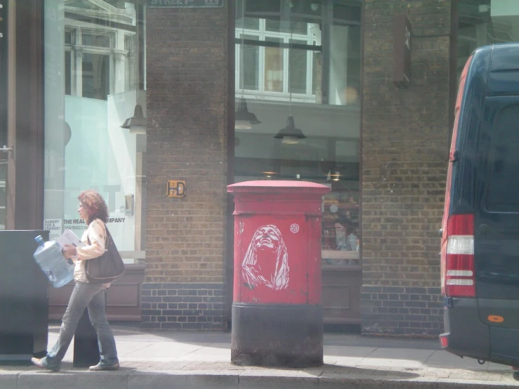 the woman is on her phone near a trash can