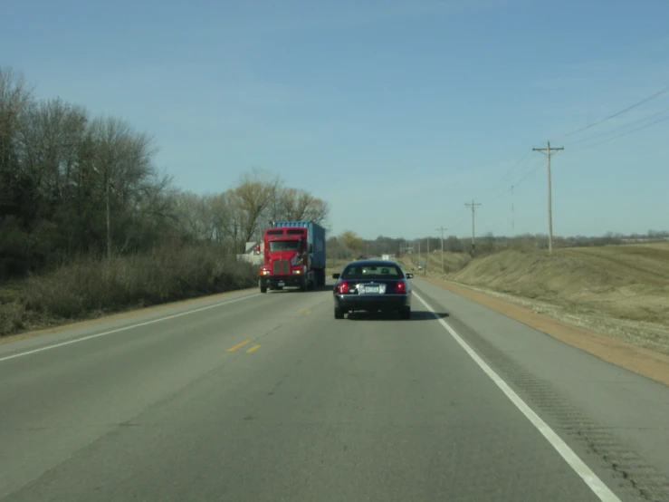 a semi truck and truck traveling down the road