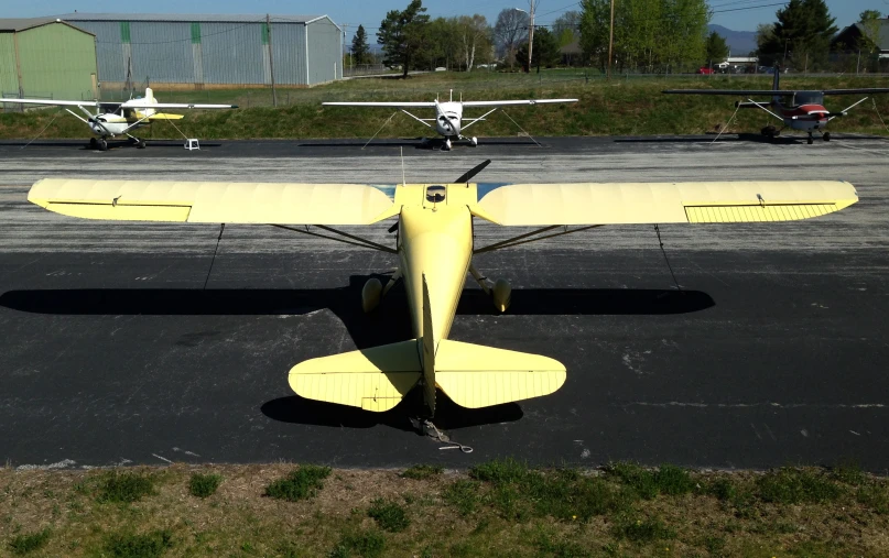 two small airplanes sit parked on an airfield