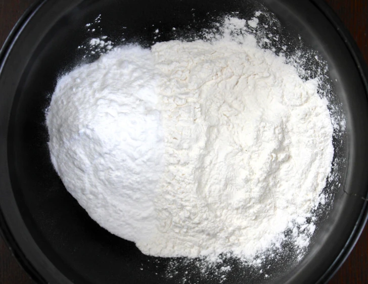 a large metal pan on a wooden table with flour