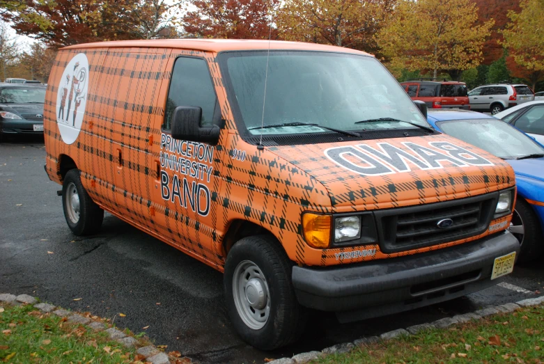 an orange van is parked in the parking lot