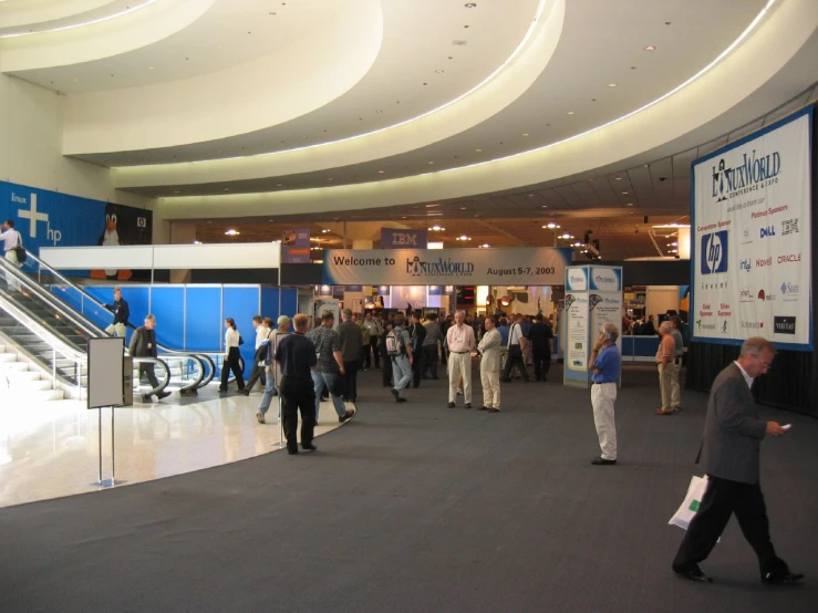a crowd of people standing around a convention hall