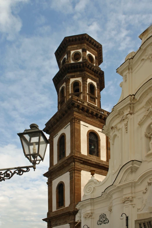 a tall bell tower sitting next to a street light