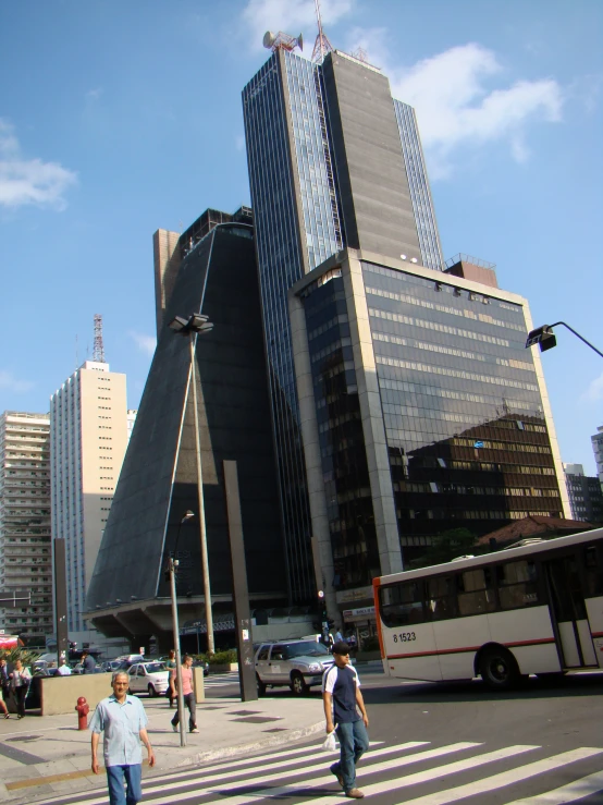 a group of people crossing a street in front of a tall building