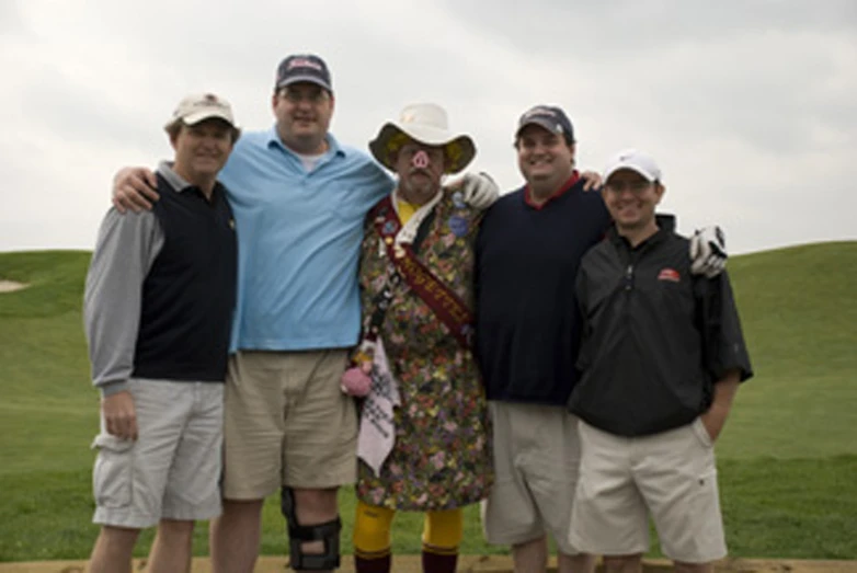 three men and two women on a green golf course