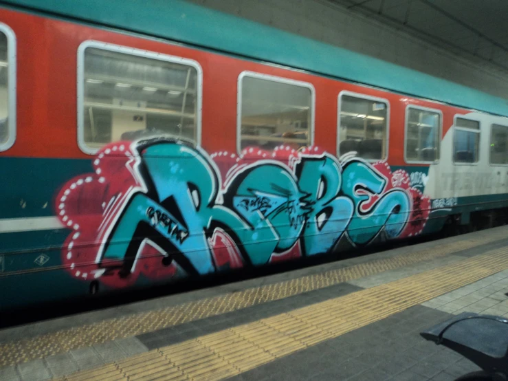 a subway car covered with graffiti in a train station