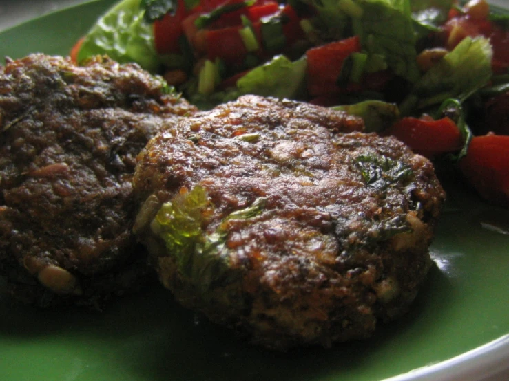 a close up of some meatballs and a salad