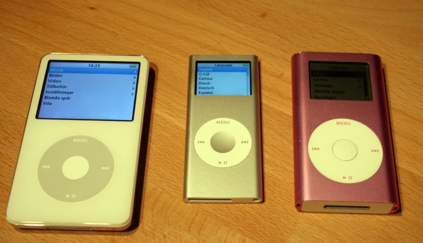 three electronic gadgets sit in the same row on a table