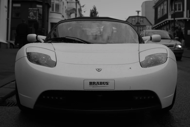 a sleek white sports car sits parked on the street