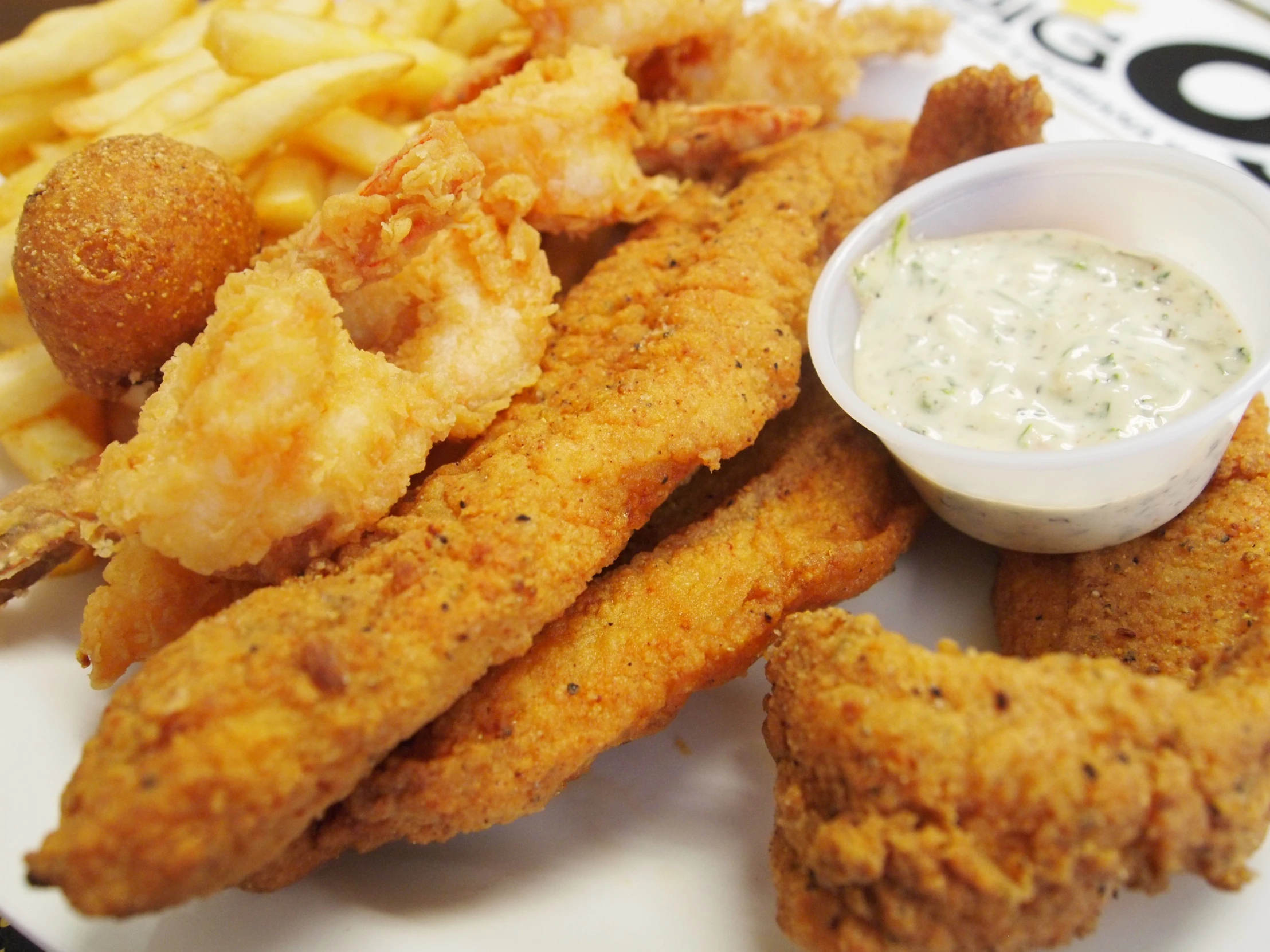 a plate topped with fried fish and fries next to dipping sauce