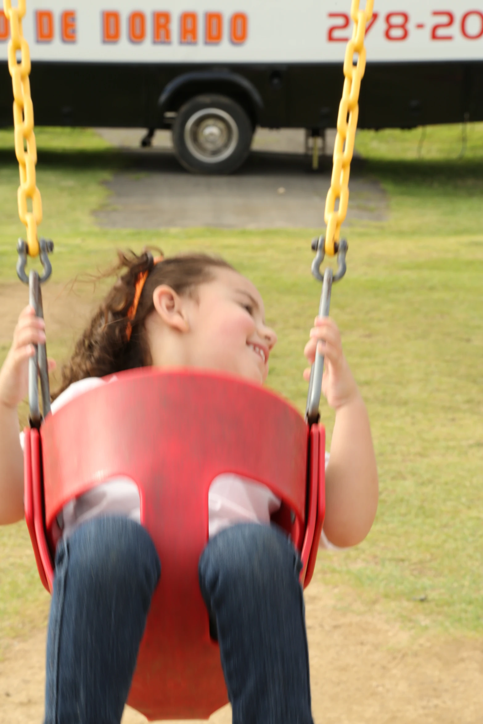 a  sits on a swing in a park