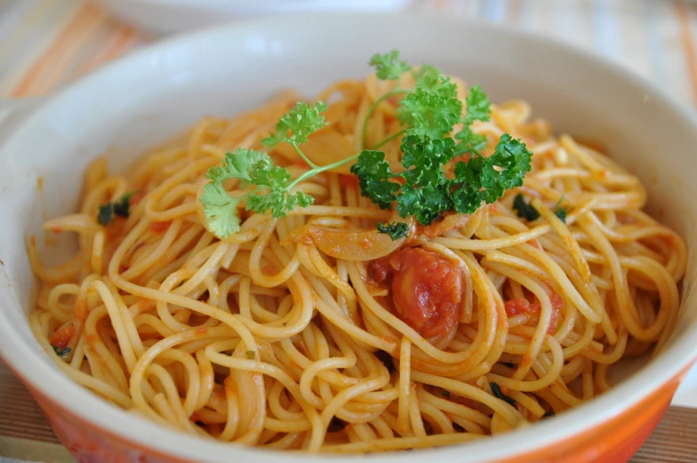 a white bowl filled with lots of pasta and parsley