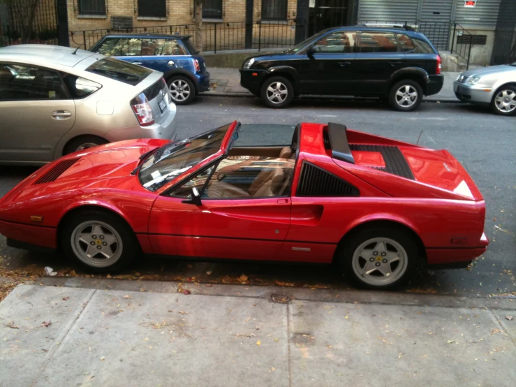 red sports car parked on the side of a street