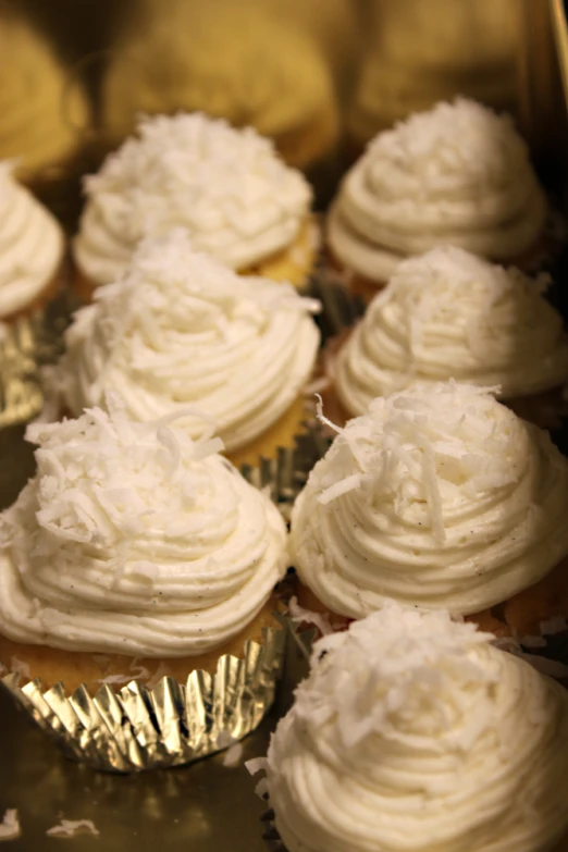 a metal pan filled with cup cakes covered in frosting