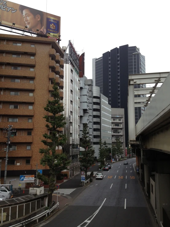 there are cars driving down the street by some tall buildings