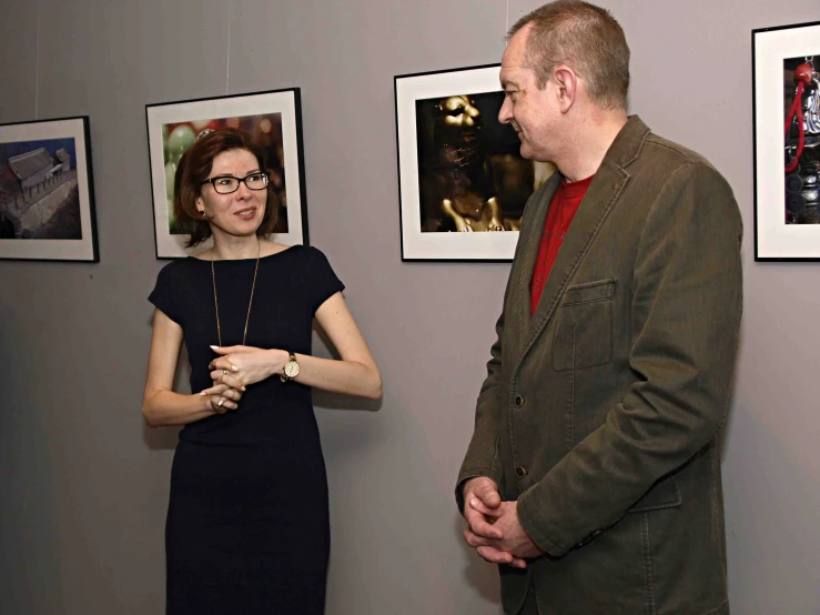 a woman standing in front of a man talking on a phone