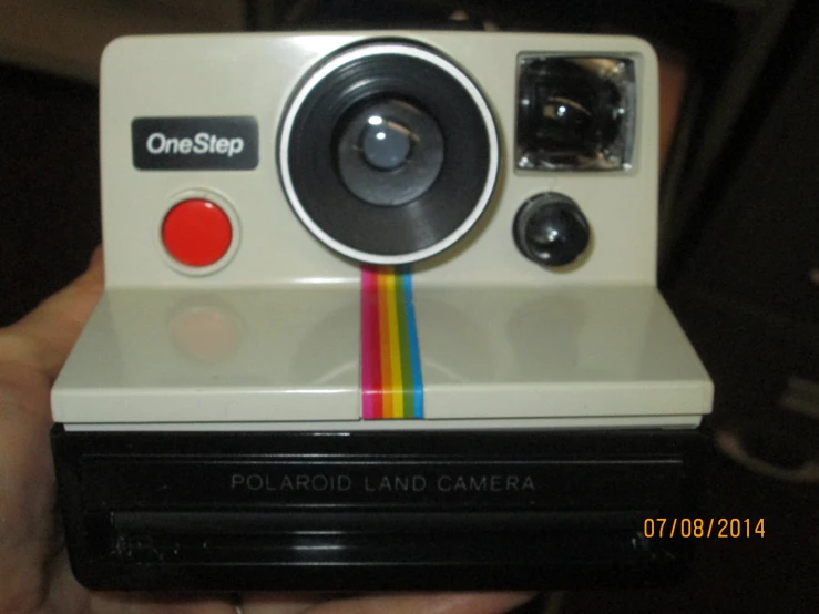 an old polaroid camera with a rainbow strip on top