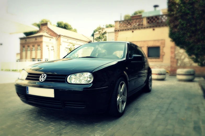 a black volkswagen golf car parked in a driveway